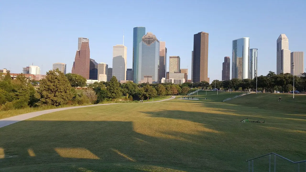 City skyline with modern skyscrapers behind a large green park.