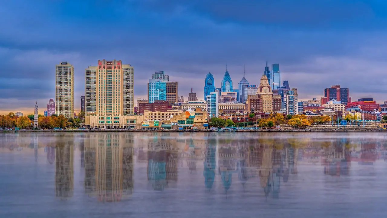 City skyline at dusk reflecting on calm water.