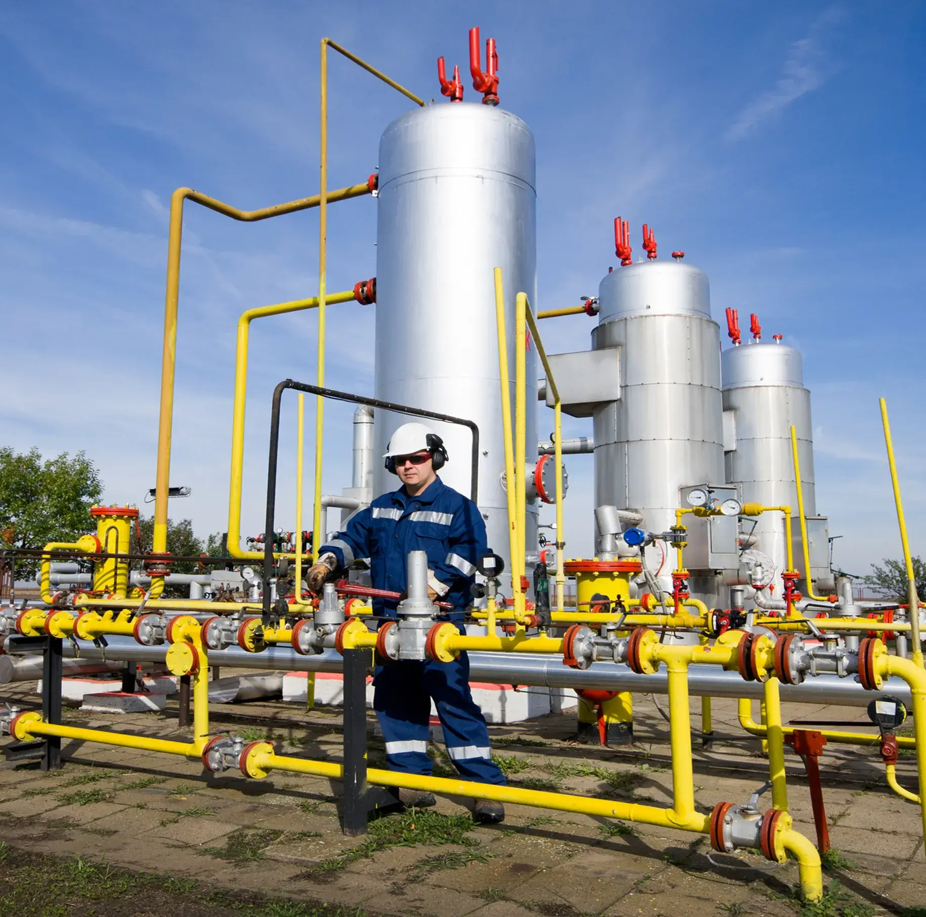 Worker operating valves at gas facility.
