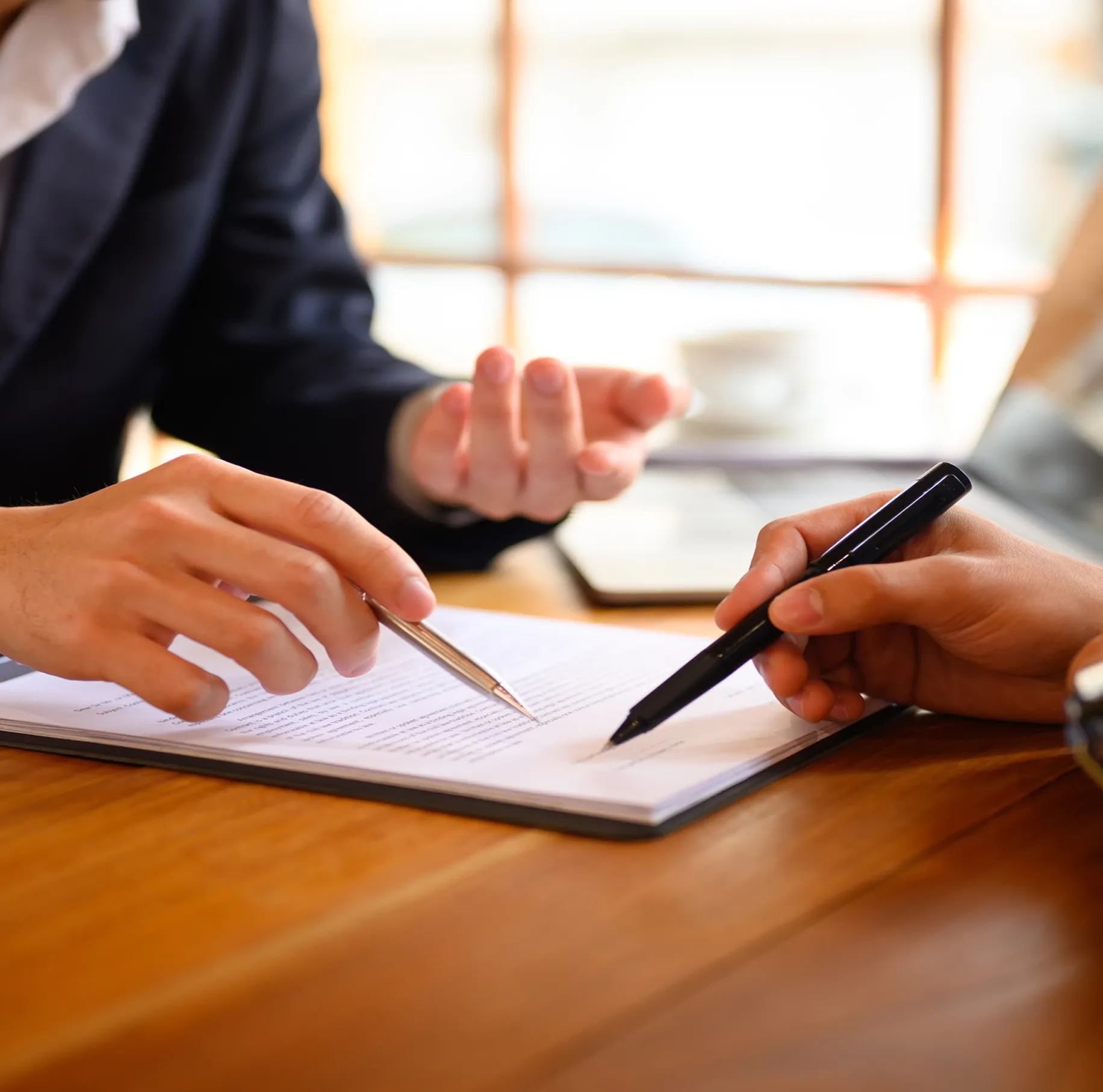 Two people discussing and signing a document.