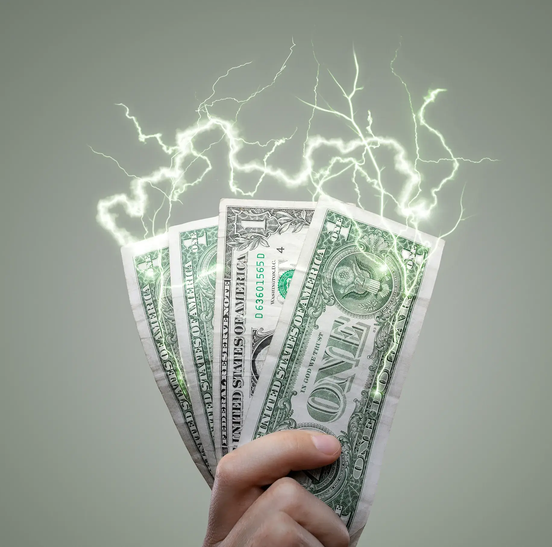 Hand holding electrified one-dollar bills.